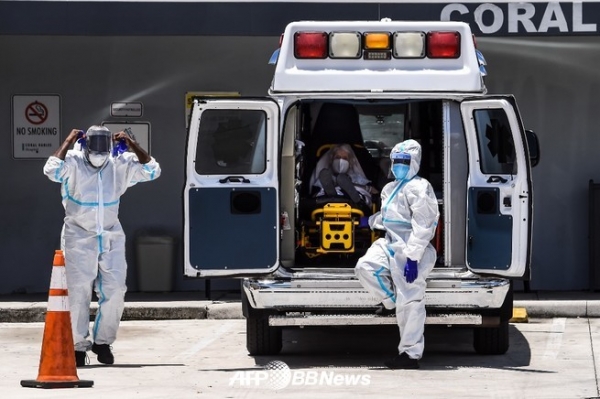 의료진이 2020년 7월 30일 마이애미 인근 코랄게블에서 코로나바이러스 환자가 치료받는 코랄게블스병원의 응급차 외부 구급차에서 환자를 이송할 준비를 하고 있다. ⓒAFPBBNews