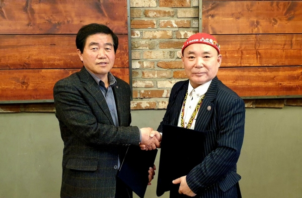 사진=한국문화콘텐츠거래소 김용관 회장과 장애인문화신문 김재덕 발행인이 업무협약을 체결하고 악수를 나누고 있다.
