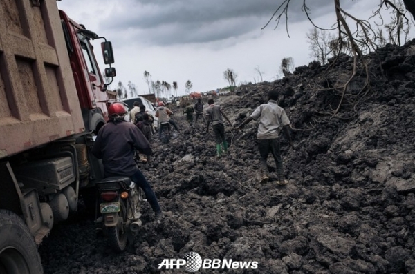 콩고 민주 공화국 동부 고마에서 굳어진 용암 위를 주행하는 오토바이와 트럭 ⓒAFPBBNews