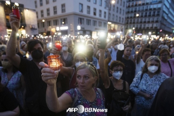 오스트리아 비엔나에서 신형 코로나 바이러스 백신 반대파의 표적이 된 끝에 ,자살한 리자 마리아 케라마야 의사의 추모 집회에 참가한 사람들(2022년 8월 1일 촬영). / ⓒAFPBBNews