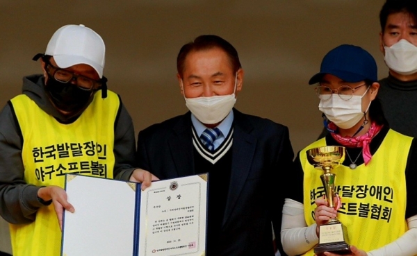 이갑용 한국발달장애인야구소프트볼협회장과 상장과 트로피를 받은 누리팀 선수들